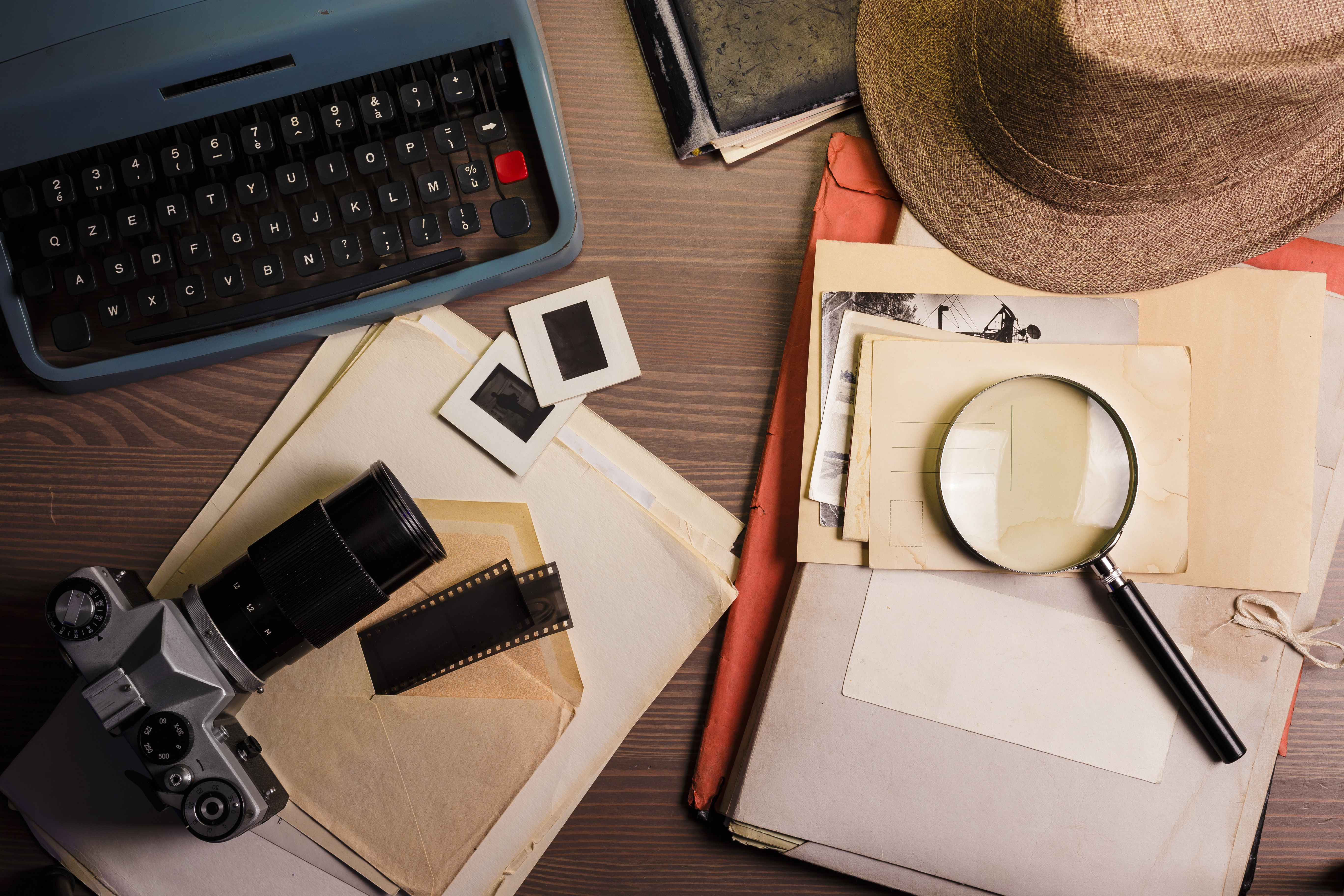 Image of desk with maginfying glass, documents, and laptop